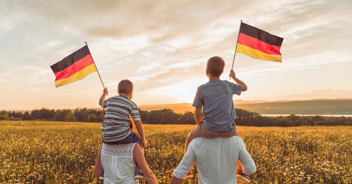 A Patriotic family waving Germany flag on sunset
