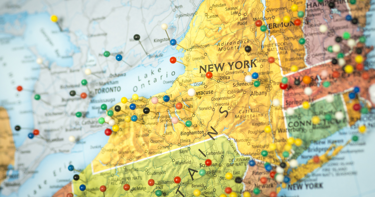 Colorful detail map macro close up with push pins marking locations throughout the United States of America NY New York