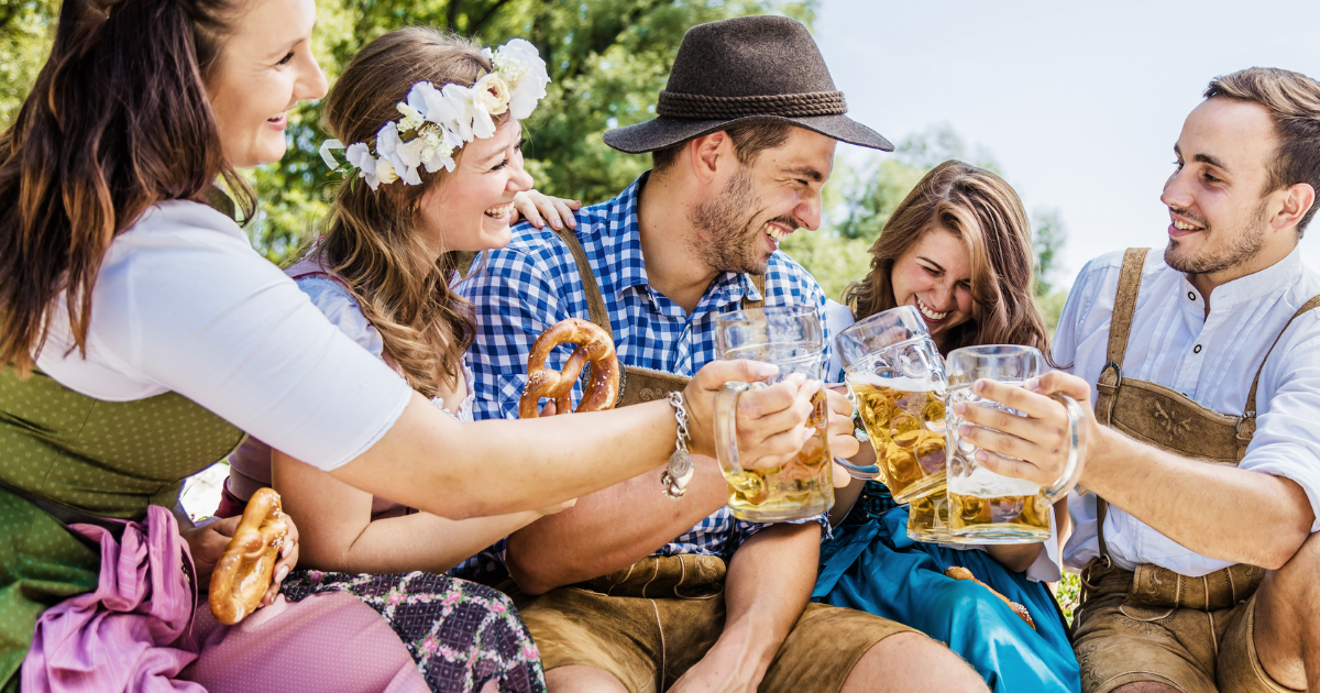Five friends having fun on Bavarian RIver and clinking beer glasses with Oktoberfest
