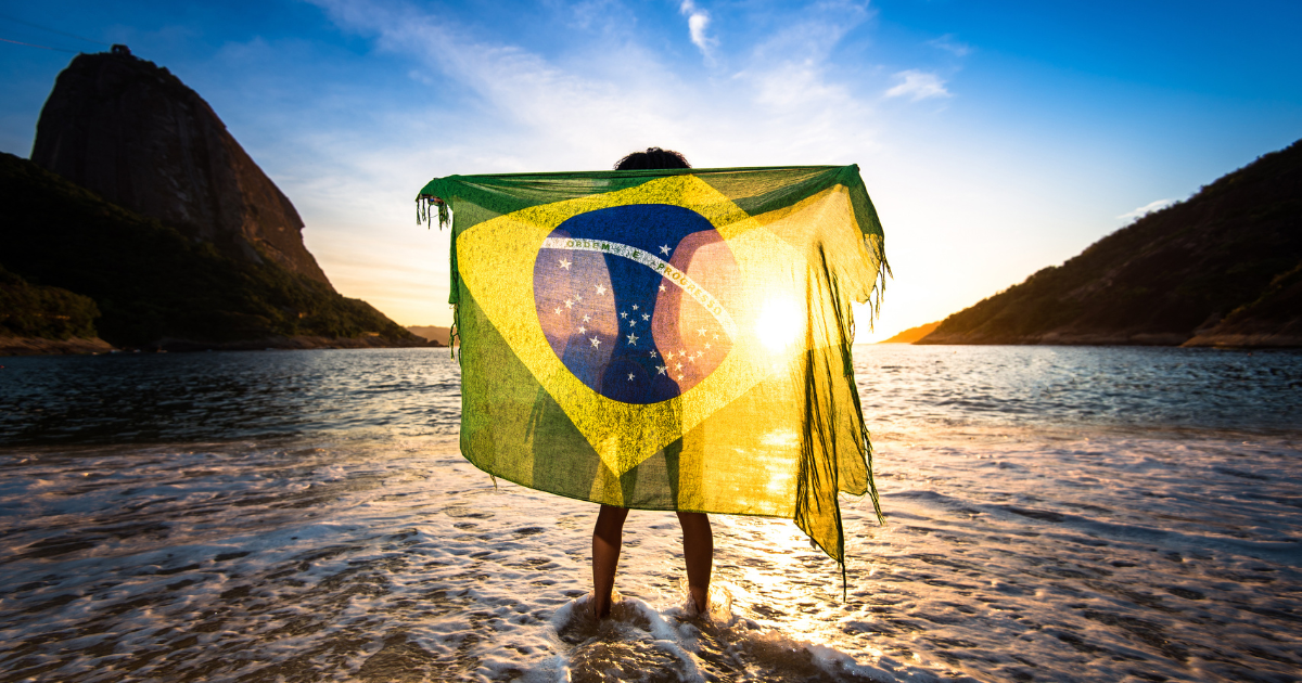 Girl Standing in Water and Holding Beach Yoke With Brazilian Flag by Sunrise, in Rio de Janeiro,