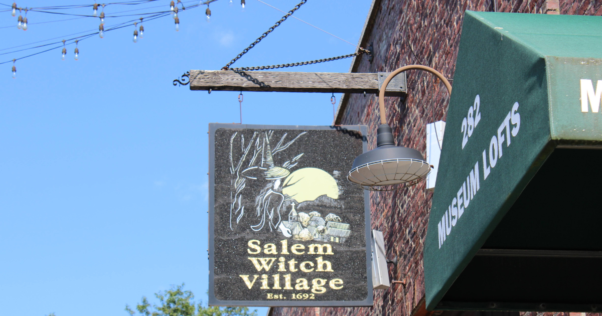 The sign for the Salem Witch Village hanging from the exterior of a building