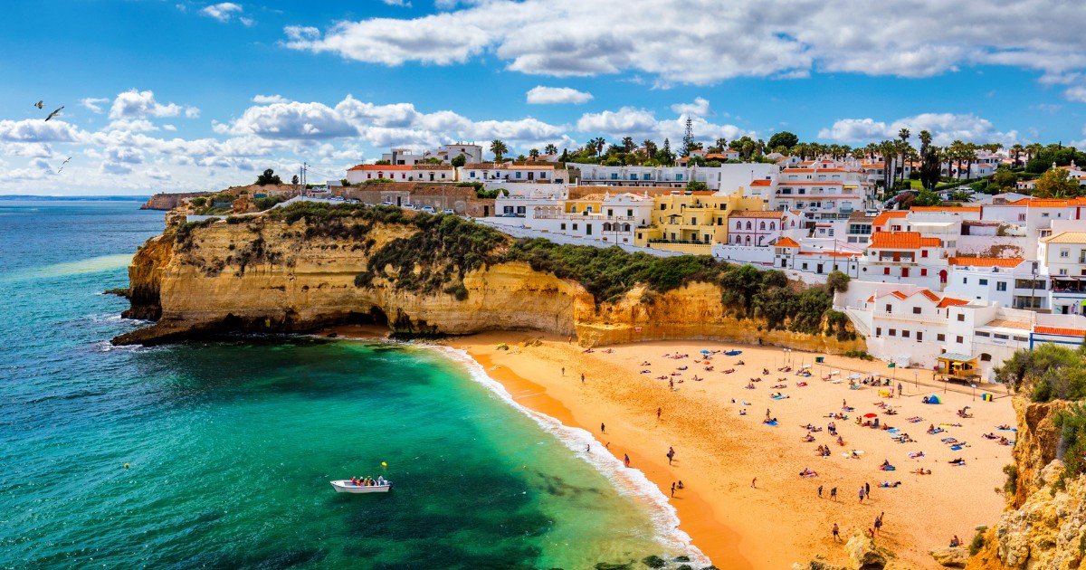 View of Carvoeiro fishing village with beautiful beach, Algarve, Portugal. View of beach in Carvoeiro town with colorful houses on coast of Portugal. The village Carvoeiro in the Algarve Portugal.