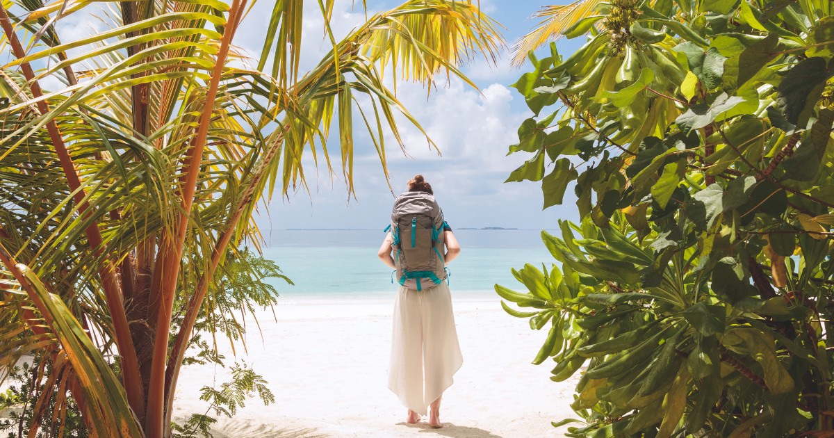 island hopping concept in the Maldives. Picture from back of a girl with a backpack.