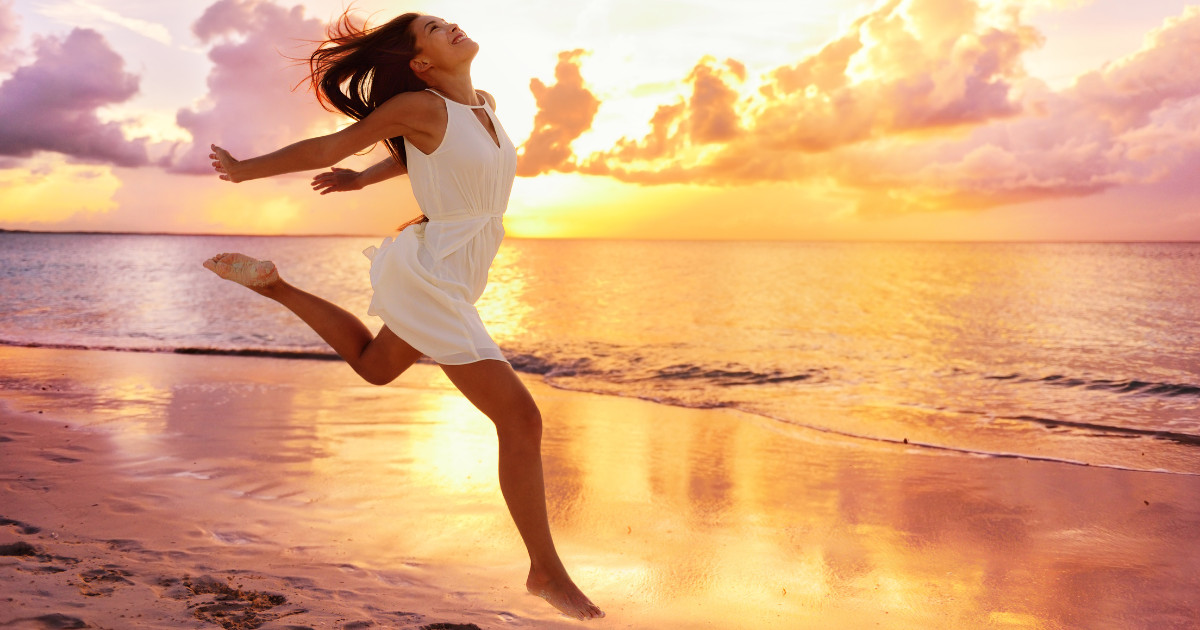 woman running on beach in sunset